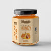 A jar of Meadows Forest Honey on a light gray background. The jar has a black lid and a beige label with an illustration of honeycomb and honey dripping from a dipper.